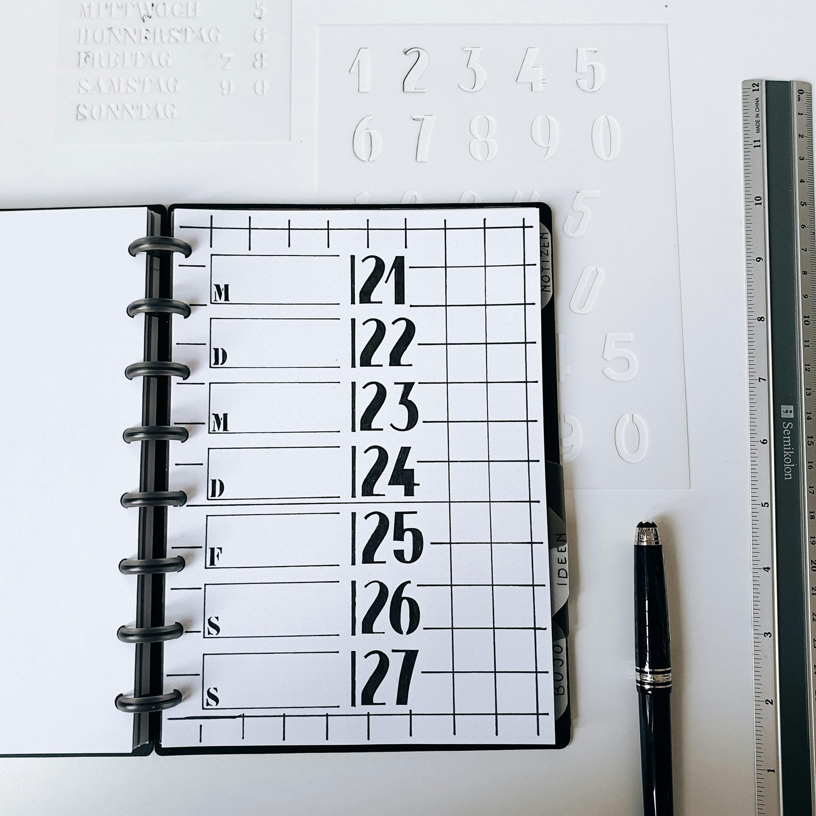 Top view of a planner and office supplies arranged on a clean desk.